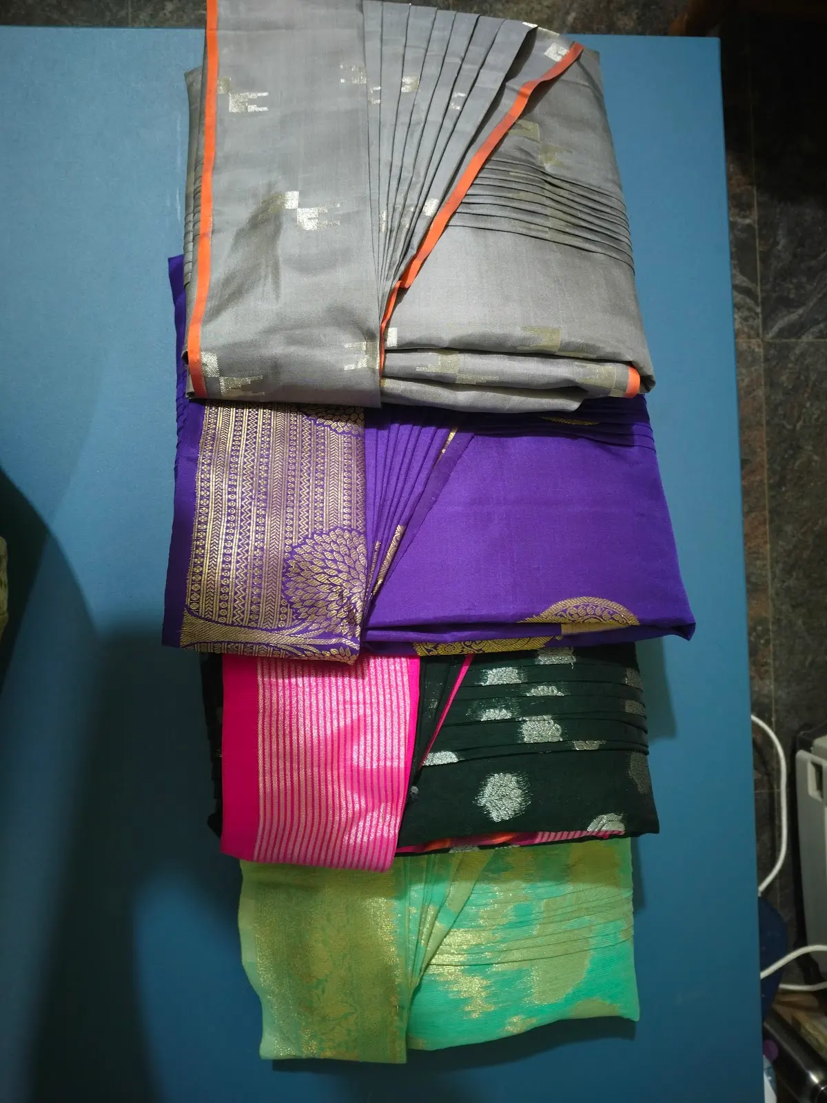A stack of folded silk sarees