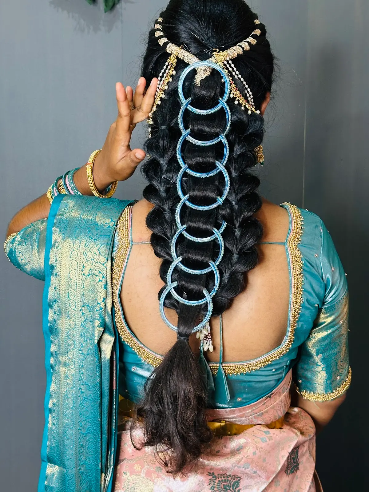 A braid dressed with a chain hair ornament, seen from behind